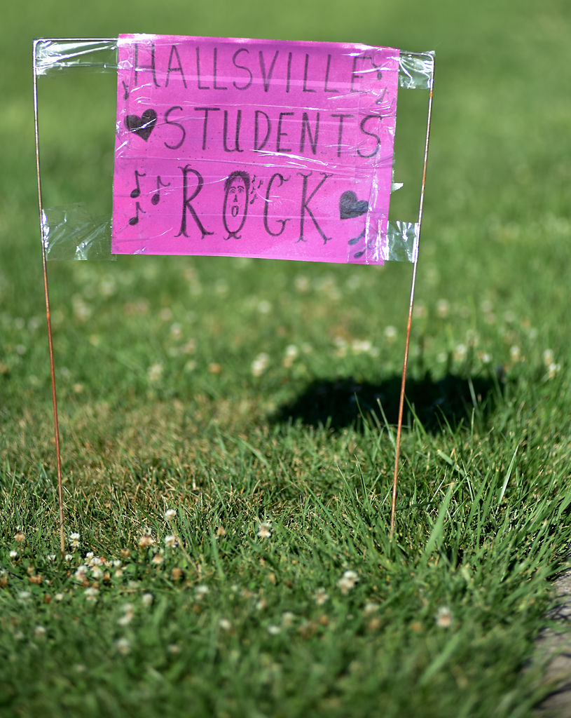 A homemade sign stands on a patch of lawn in Hallsville
